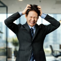 頭を抱えて悩む男性